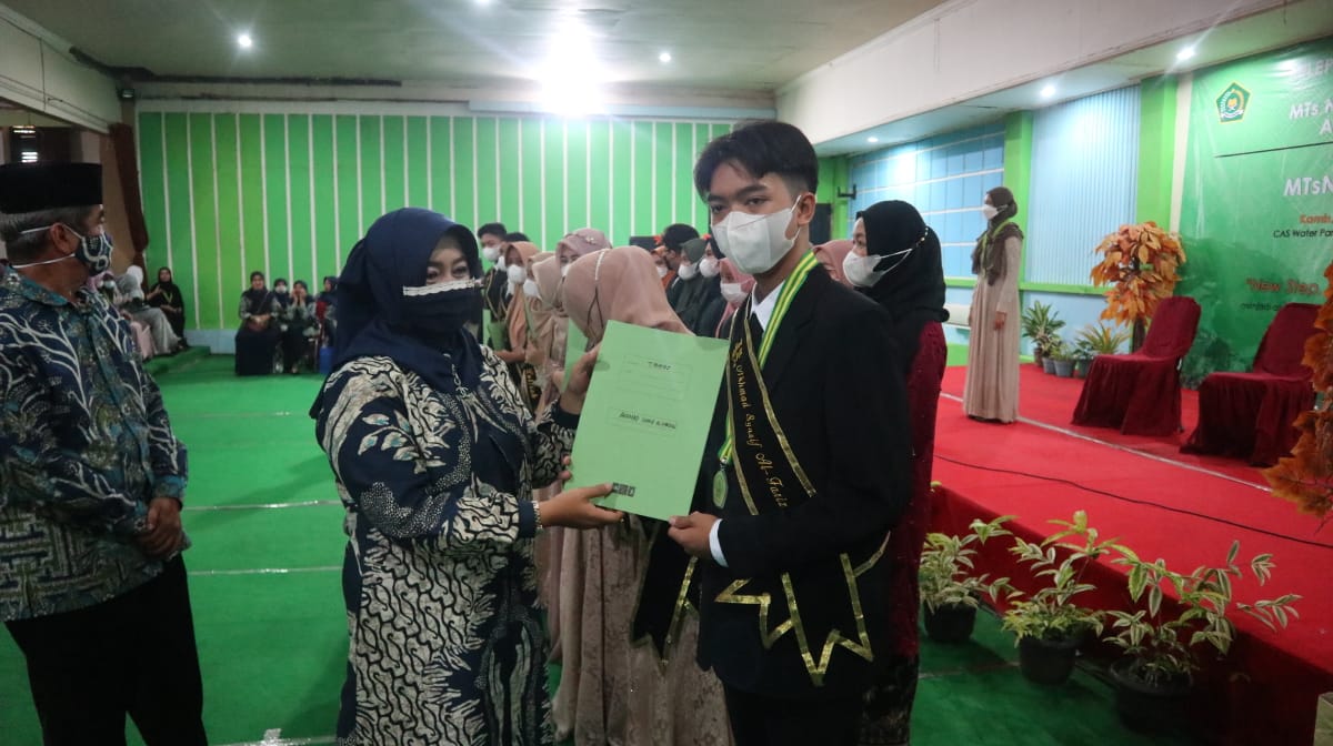 Kepala MTsN 1 Pandeglang Hj. Tati Jumiati, M.Pd didampingi ketua Komite E. Haromaen, S.Pd,M.S.I menyerahkan piagam penghargaan kepada 10 terbaik Hafidz Quran 2 Juz.